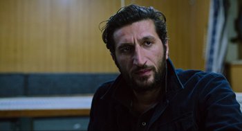 Movie still from “Zero Dark Thirty” (2012), directed by Kathryn Bigelow – A person wearing a black shirt; Close Up shot, Over the shoulder angle