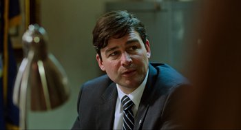 Movie still from “Zero Dark Thirty” (2012), directed by Kathryn Bigelow – A person wearing a suit and tie; Close Up shot, Over the shoulder angle