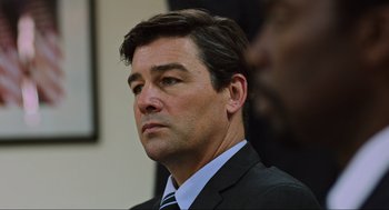 Movie still from “Zero Dark Thirty” (2012), directed by Kathryn Bigelow – A person wearing a suit and tie; Close Up shot, Over the shoulder angle