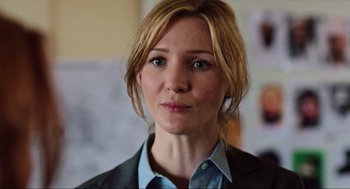 Movie still from “Zero Dark Thirty” (2012), directed by Kathryn Bigelow – A person wearing a suit and tie; Close Up shot, Over the shoulder angle