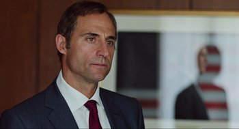 Movie still from “Zero Dark Thirty” (2012), directed by Kathryn Bigelow – A person wearing a suit and tie; Close Up shot, Over the shoulder angle