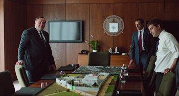 Movie still from “Zero Dark Thirty” (2012), directed by Kathryn Bigelow – Two men standing in front of a large model of a building; Medium shot, High angle
