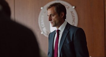 Movie still from “Zero Dark Thirty” (2012), directed by Kathryn Bigelow – A person wearing a suit and tie; Close Up shot, Over the shoulder angle