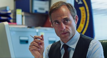 Movie still from “Zero Dark Thirty” (2012), directed by Kathryn Bigelow – A person wearing a suit and tie; Close Up shot, Over the shoulder angle