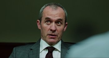 Movie still from “Zero Dark Thirty” (2012), directed by Kathryn Bigelow – A person wearing a suit and tie; Close Up shot, Over the shoulder angle