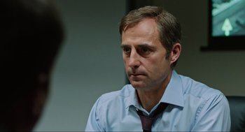 Movie still from “Zero Dark Thirty” (2012), directed by Kathryn Bigelow – A person wearing a shirt and a tie; Close Up shot, Over the shoulder angle