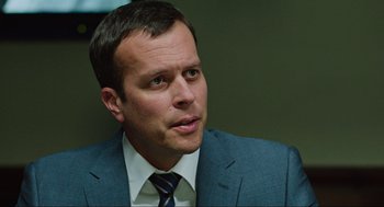 Movie still from “Zero Dark Thirty” (2012), directed by Kathryn Bigelow – A person wearing a suit and tie; Close Up shot, Over the shoulder angle