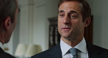 Movie still from “Zero Dark Thirty” (2012), directed by Kathryn Bigelow – A person wearing a suit and tie; Close Up shot, Over the shoulder angle