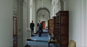 Movie still from “Zero Dark Thirty” (2012), directed by Kathryn Bigelow – Two men in suits are walking through a library; Wide shot, High angle