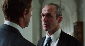 Movie still from “Zero Dark Thirty” (2012), directed by Kathryn Bigelow – A man in a suit and tie looking into a mirror; Close Up shot, Over the shoulder angle