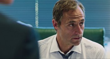 Movie still from “Zero Dark Thirty” (2012), directed by Kathryn Bigelow – A person wearing a shirt and a tie; Close Up shot, Over the shoulder angle