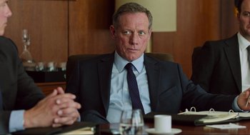 Movie still from “Zero Dark Thirty” (2012), directed by Kathryn Bigelow – A man sitting at a table in a suit; Close Up shot, Over the shoulder angle