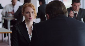 Movie still from “Zero Dark Thirty” (2012), directed by Kathryn Bigelow – A woman with red hair is looking at a man in a black suit; Medium shot, Over the shoulder angle