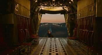 Movie still from “Zero Dark Thirty” (2012), directed by Kathryn Bigelow – A person sitting on the back of an airplane looking out of the door; Extreme Wide shot, Low angle