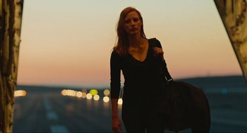 Movie still from “Zero Dark Thirty” (2012), directed by Kathryn Bigelow – A woman in a black shirt is holding a purse; Medium shot, Low angle