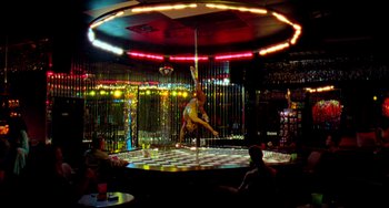A woman is performing a pole dance in a bar