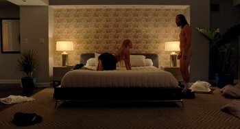 A man and a woman are laying on a bed in a bedroom