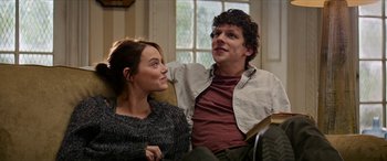 Movie still from “Zombieland: Double Tap” (2019), directed by Ruben Fleischer – A man and a woman sitting on a couch together; Medium shot, Over the shoulder angle