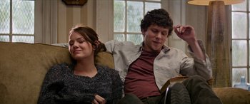Movie still from “Zombieland: Double Tap” (2019), directed by Ruben Fleischer – A man and a woman sitting on a couch reading; Medium shot, Over the shoulder angle