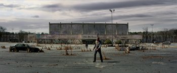 Movie still from “Zombieland: Double Tap” (2019), directed by Ruben Fleischer – A man standing in an empty parking lot; Extreme Wide shot, Low angle