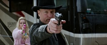 Movie still from “Zombieland: Double Tap” (2019), directed by Ruben Fleischer – A man wearing a black hat and holding a gun; Close Up shot, Low angle
