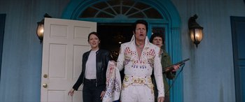 Movie still from “Zombieland: Double Tap” (2019), directed by Ruben Fleischer – A woman and a man dressed as elvis presley; Medium shot, Low angle