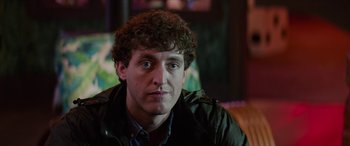 Movie still from “Zombieland: Double Tap” (2019), directed by Ruben Fleischer – A person sitting in a room; Close Up shot, Over the shoulder angle