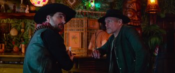 Movie still from “Zombieland: Double Tap” (2019), directed by Ruben Fleischer – Two men in black hats are talking to each other; Medium shot, Low angle