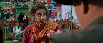 Movie still from “Zombieland: Double Tap” (2019), directed by Ruben Fleischer – A man with long brown hair wearing a red and orange scarf; Close Up shot, Over the shoulder angle