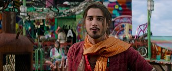 Movie still from “Zombieland: Double Tap” (2019), directed by Ruben Fleischer – A man with long brown hair wearing a red shirt and a yellow scarf; Medium shot, Over the shoulder angle