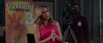 Movie still from “Zombieland: Double Tap” (2019), directed by Ruben Fleischer – A woman in a pink dress sitting in front of a camera; Medium shot, Over the shoulder angle