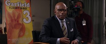 Movie still from “Zombieland: Double Tap” (2019), directed by Ruben Fleischer – A man in a suit and tie sitting in a chair; Medium shot, Low angle