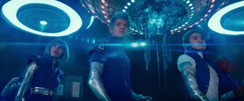 Movie still from “Zombies 3” (2022), directed by Paul Hoen – A man in a blue suit with a metal arm; Medium shot, Low angle