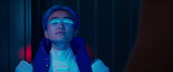 Movie still from “Zombies 3” (2022), directed by Paul Hoen – A person with blue hair and glasses in a room; Close Up shot, Low angle