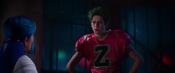 Movie still from “Zombies 3” (2022), directed by Paul Hoen – A man in a football uniform with green hair; Medium shot, Over the shoulder angle