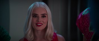 Movie still from “Zombies 3” (2022), directed by Paul Hoen – A woman with blonde hair and red lipstick smiles; Close Up shot, Over the shoulder angle