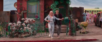 Movie still from “Zombies 3” (2022), directed by Paul Hoen – A man and a woman walking down the sidewalk; Wide shot, Low angle