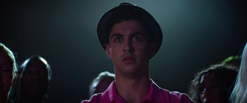Movie still from “Zombies 3” (2022), directed by Paul Hoen – A young man wearing a pink shirt and a black hat; Close Up shot, Low angle