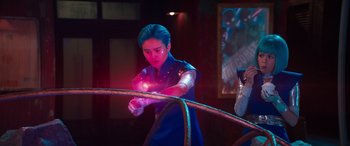 Movie still from “Zombies 3” (2022), directed by Paul Hoen – A man holding a glowing object while standing next to a hula hoop; Medium shot, Over the shoulder angle