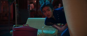 Movie still from “Zombies 3” (2022), directed by Paul Hoen – A person with blue hair is leaning on a chair; Medium shot, Over the shoulder angle