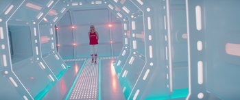 Movie still from “Zombies 3” (2022), directed by Paul Hoen – A woman standing in a room with lights on the walls; Wide shot, Low angle