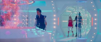 Movie still from “Zombies 3” (2022), directed by Paul Hoen – A man and a woman are standing in a room; Wide shot, Over the shoulder angle