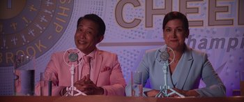 Movie still from “Zombies 3” (2022), directed by Paul Hoen – A man and a woman sitting in front of microphones in front of microphones; Medium shot, Over the shoulder angle