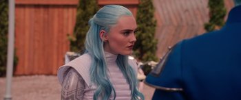 Movie still from “Zombies 3” (2022), directed by Paul Hoen – A woman with blue hair is standing in front of some trees; Close Up shot, Over the shoulder angle