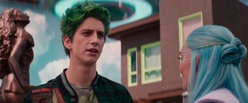 Movie still from “Zombies 3” (2022), directed by Paul Hoen – A man with green hair standing in front of a building; Medium shot, Over the shoulder angle