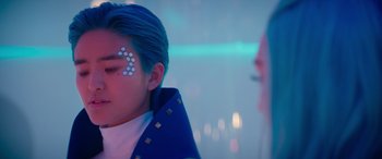 Movie still from “Zombies 3” (2022), directed by Paul Hoen – A person with blue hair and a face painting; Close Up shot, Over the shoulder angle