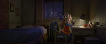 Movie still from “Zootopia” (2016), directed by Jared Bush – A girl sitting at a table in a room with a bed; Wide shot, High angle