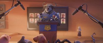 Movie still from “Zootopia” (2016), directed by Jared Bush – An animated character is speaking at a press conference; Medium shot, Over the shoulder angle