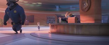 Movie still from “Zootopia” (2016), directed by Jared Bush – An animated scene of a person sitting at a desk; Wide shot, Over the shoulder angle