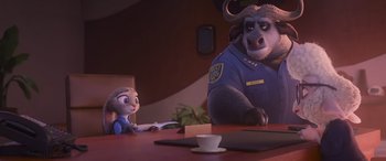 Movie still from “Zootopia” (2016), directed by Jared Bush – An animal that is sitting on the table next to a girl; Medium shot, Over the shoulder angle